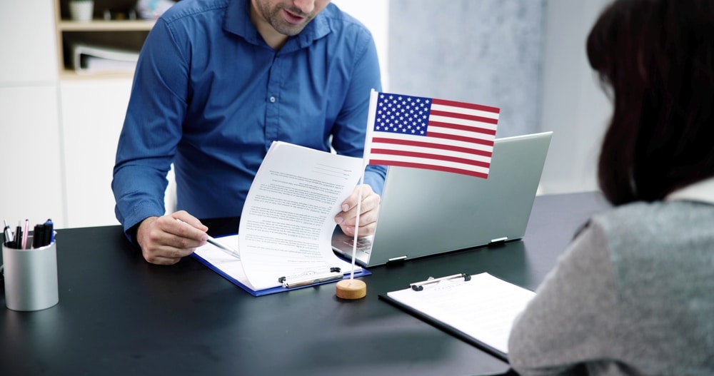 female filling an immigration application with the help of an immigration attorney