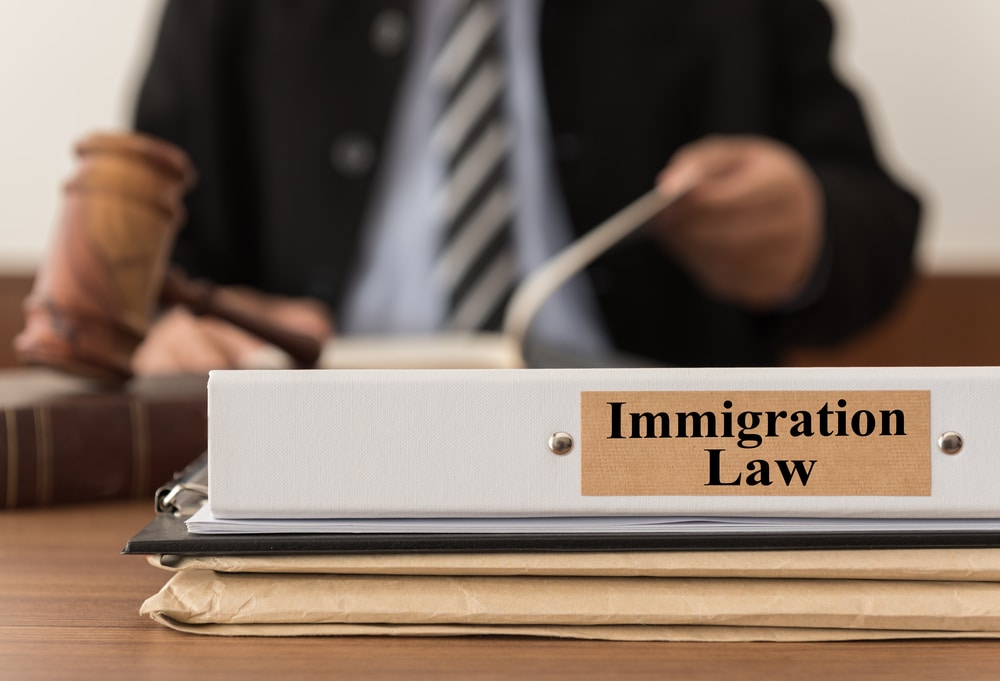 close the immigration legal lawsuit file with the judge considering a lawsuit in the background. immigration law concept.