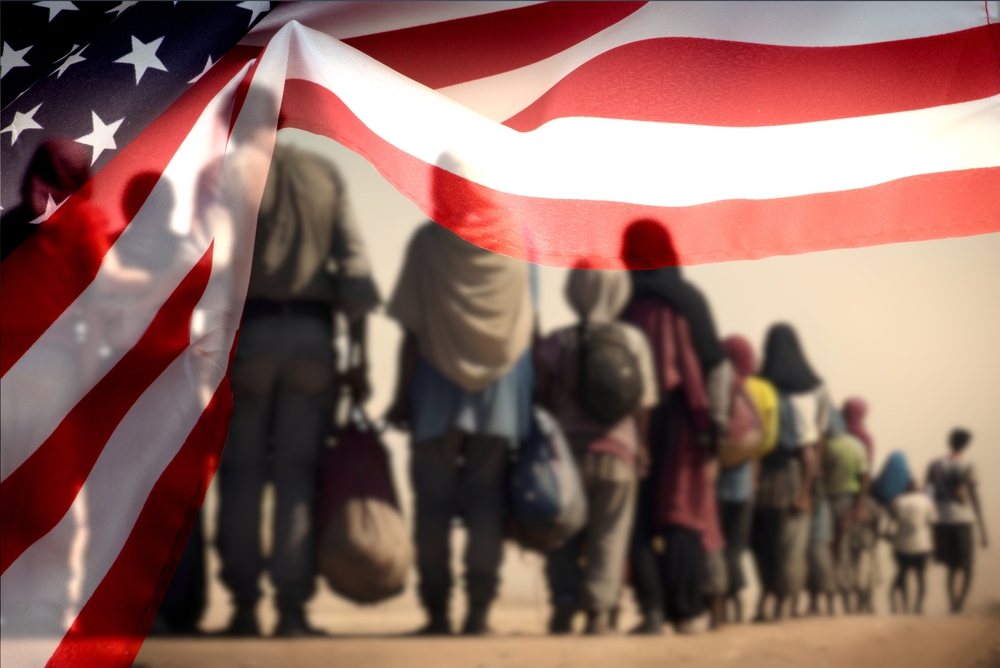 A group of migrants and the United States flag